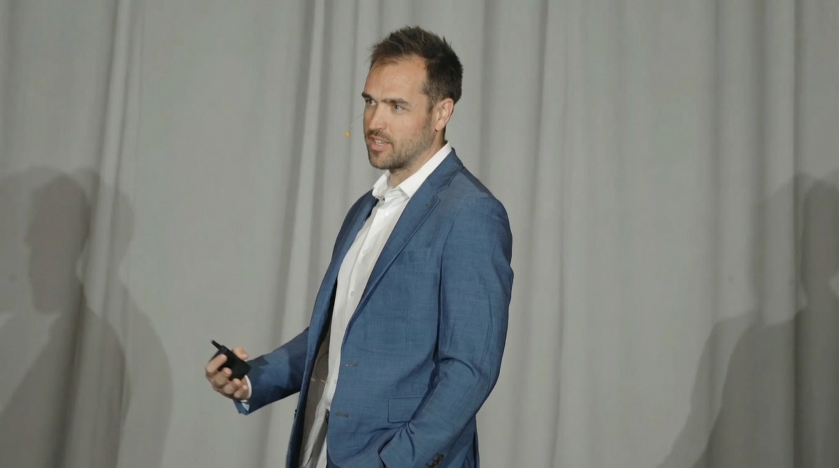 Nick Fischer, founder of CHIROBASIX, on stage at a chiropractic marketing event.